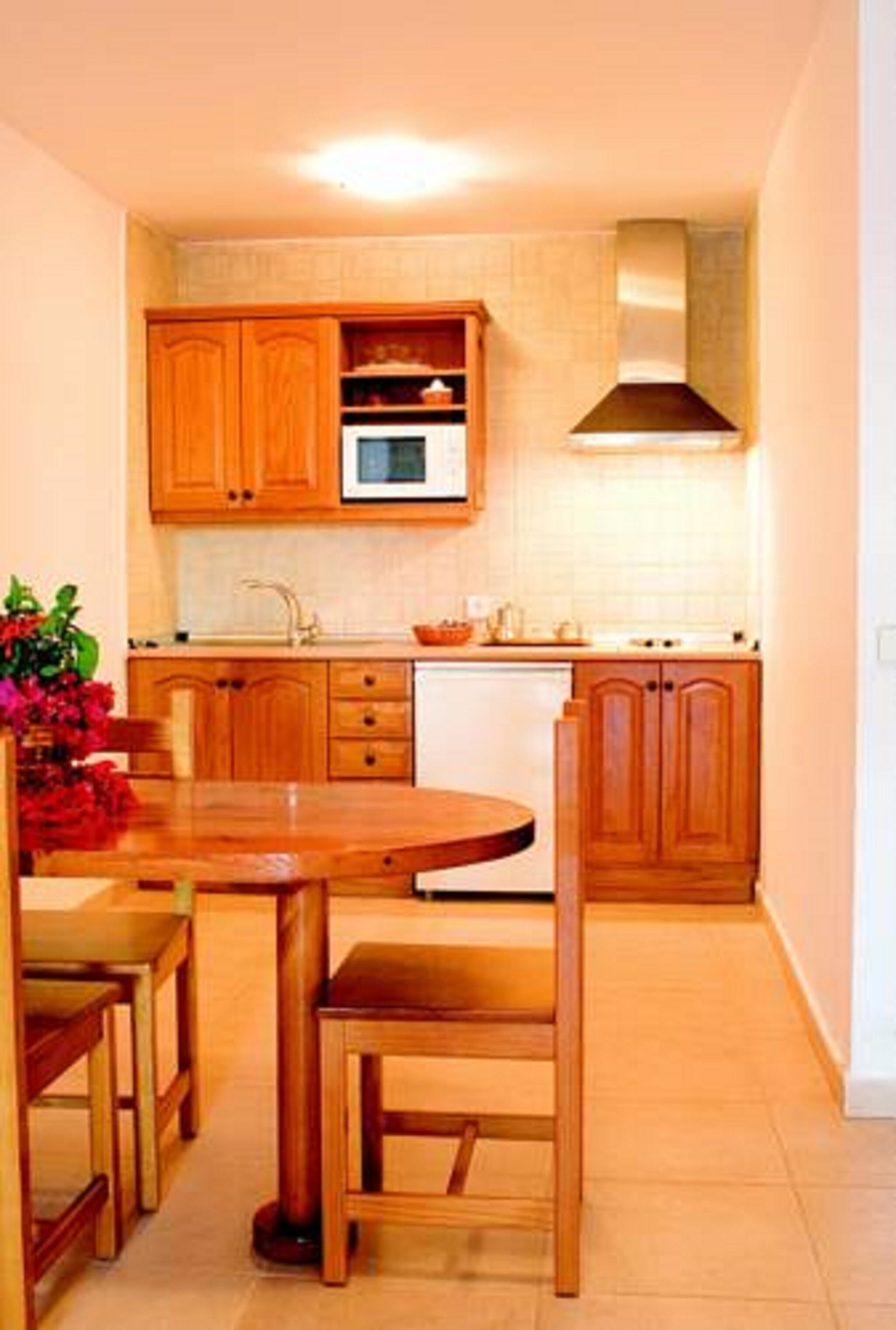 A kitchen with wooden cabinets, a microwave, and a stove.