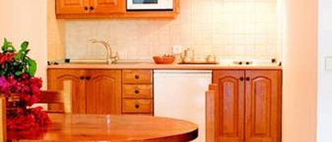 A kitchen with wooden cabinets, a microwave, and a stove.