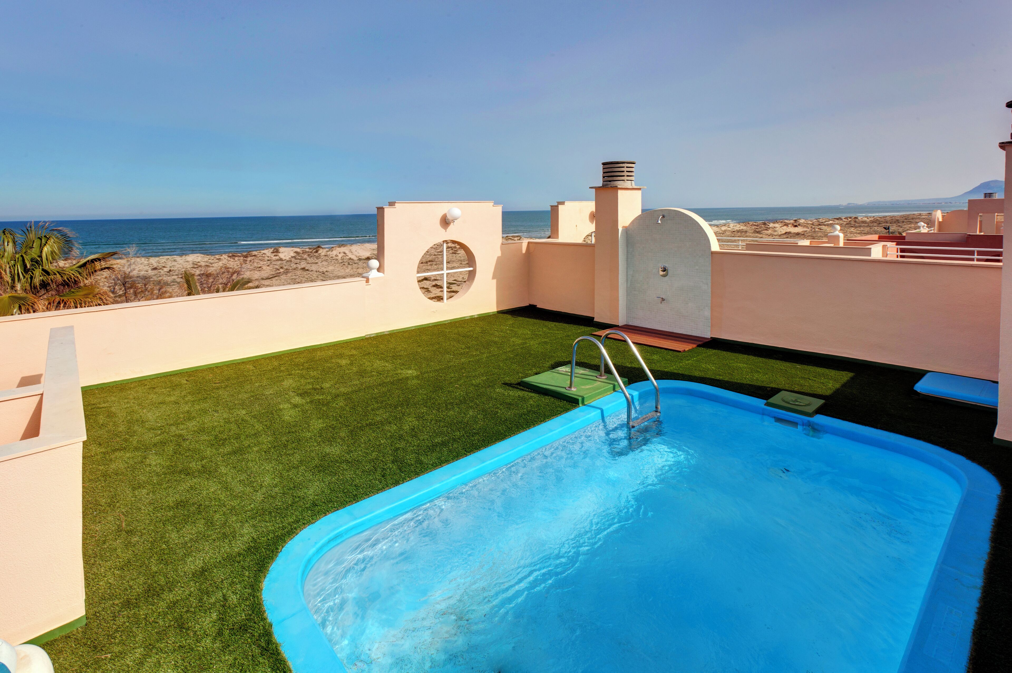 A rooftop pool with a view of the beach and ocean.