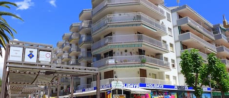 Un hotel de varios pisos con balcones, una galería techada y tiendas de souvenirs.