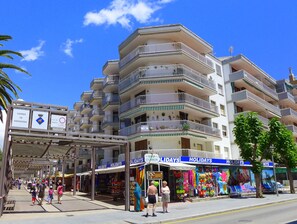 A multi-story hotel with balconies, a covered walkway, and holiday shops. - Rentalmar Bahia Dorada and Iris (Salou)