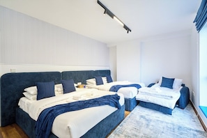 A hotel room with two beds, a large headboard, and a ceiling light. - Ocean Views / Karaoke / Foosball / Gym / Pool (Dubai)