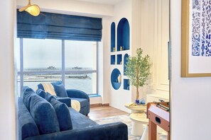 Ein Wohnzimmer mit einer Couch, einem Couchtisch und Blick auf das Wasser.
