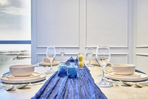 Une table à manger dressée avec des assiettes, des verres et un centre de table décoratif.