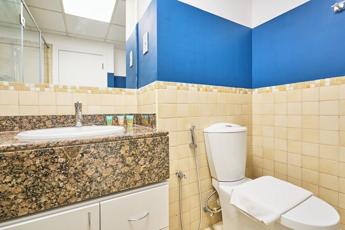 Ein Badezimmer mit Granitwaschtisch, Toilette und Dusche.