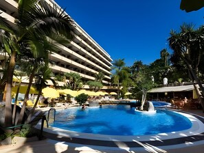 A hotel with a large pool, palm trees, and yellow umbrellas. - Fergus Puerto de la Cruz (Puerto de la Cruz)