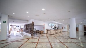 A spacious lobby with a marble floor, a reception desk, and a stone wall feature. - Fergus Puerto de la Cruz (Puerto de la Cruz)
