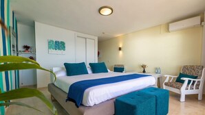 Ein Schlafzimmer mit einem Bett, einem Sessel, einem kleinen Tisch und einer Wandklimaanlage.