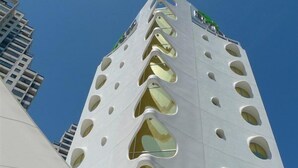 A modern building with a unique architectural design featuring multiple arched windows and a white facade. - Riviera Beach Hotel - Adults Only (Benidorm)