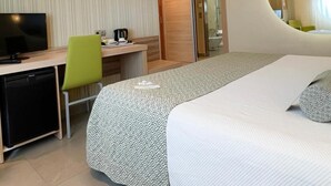 A hotel room with a bed, desk, chair, television, and a mirror. - Riviera Beach Hotel - Adults Only (Benidorm)