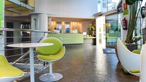 A reception area with a reception desk, green chairs, and a glass wall. - Riviera Beach Hotel - Adults Only (Benidorm)