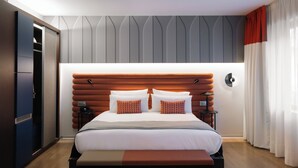 A modern hotel room with a large bed, a bench, a wardrobe, and a nightstand. - Hotel Indigo Barcelona Gran Via Plaza Espana, an IHG Hotel (Barcelona)