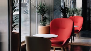A modern interior with a red chair, a white table, and a potted plant. - Hotel Indigo Barcelona Gran Via Plaza Espana, an IHG Hotel (Barcelona)