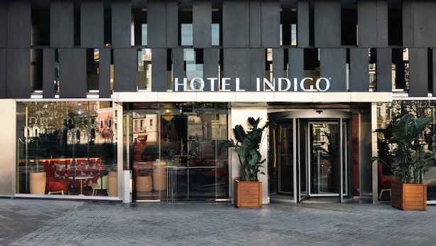 The exterior of Hotel Indigo with a modern facade, large glass windows, and a revolving door. - Hotel Indigo Barcelona Gran Via Plaza Espana, an IHG Hotel (Barcelona)