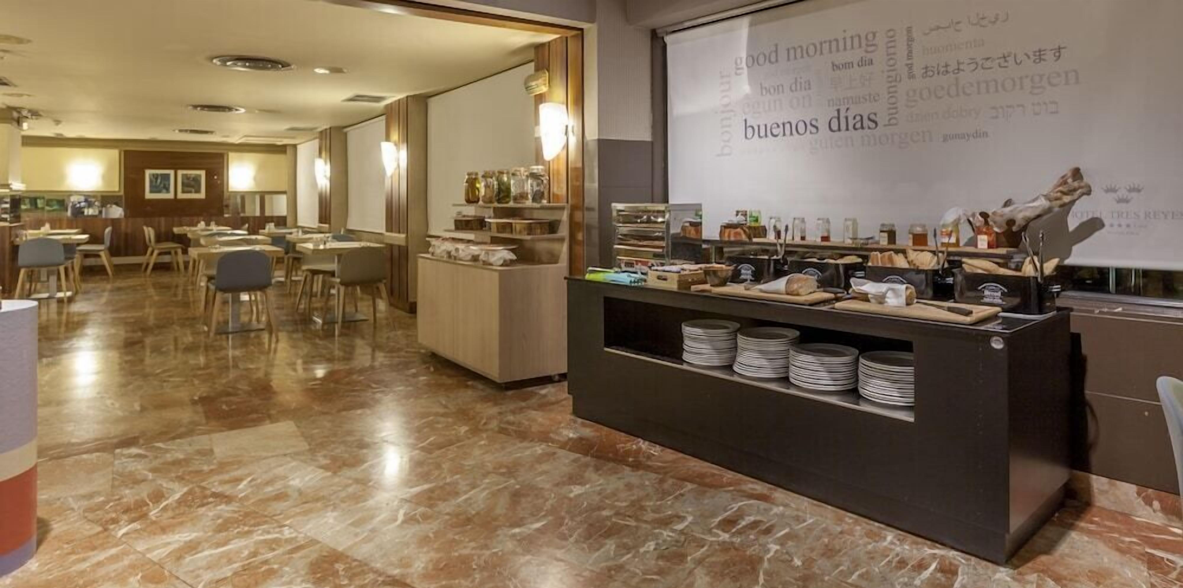 Un área de desayuno de hotel con barra libre, que incluye diversos alimentos y condimentos.