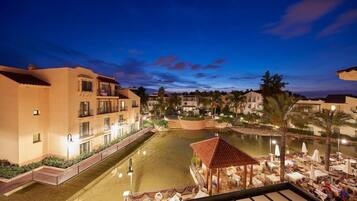 A hotel with a pool, outdoor seating, and a view of the surrounding buildings.