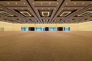 A large, empty conference room with a carpeted floor and a modern ceiling design featuring recessed lighting and geometric patterns. - Portaventura Hotel Portaventura (Salou)