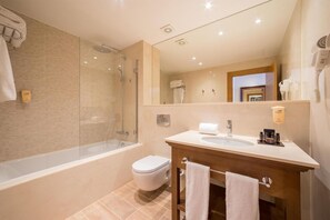 Ein modernes Badezimmer mit einer Duschkabine, einer freistehenden Toilette und einem Waschtisch mit Spüle und Handtuchhalter.