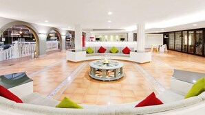 Eine geräumige Lobby mit einer zentralen Sitzecke, einem Empfangsbereich und einem modernen Design.