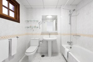 Ein Badezimmer mit Toilette, Waschbecken und Badewanne.
