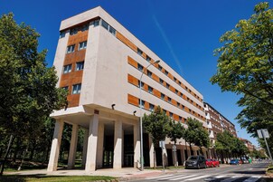Un edificio de varios pisos con un estilo arquitectónico moderno, que presenta un techo plano y una serie de ventanas.