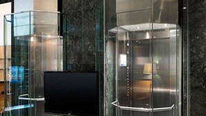 Two glass elevator cabins with metallic finishes, set against a marble wall, in a modern lobby. - Holiday Inn Express Logrono Rioja By IHG (Logroño)