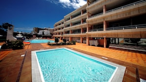 A hotel with a swimming pool, multiple floors, and a clear blue sky. - Montemar Apartments (San Bartolomé de Tirajana)