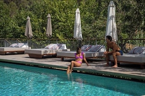 Area piscina con lettini e ombrelloni.
