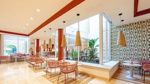 A spacious lobby with a seating area, large windows, and a patterned wall. - Intelier Rosella Hotel (Sant Llorenc des Cardassar)