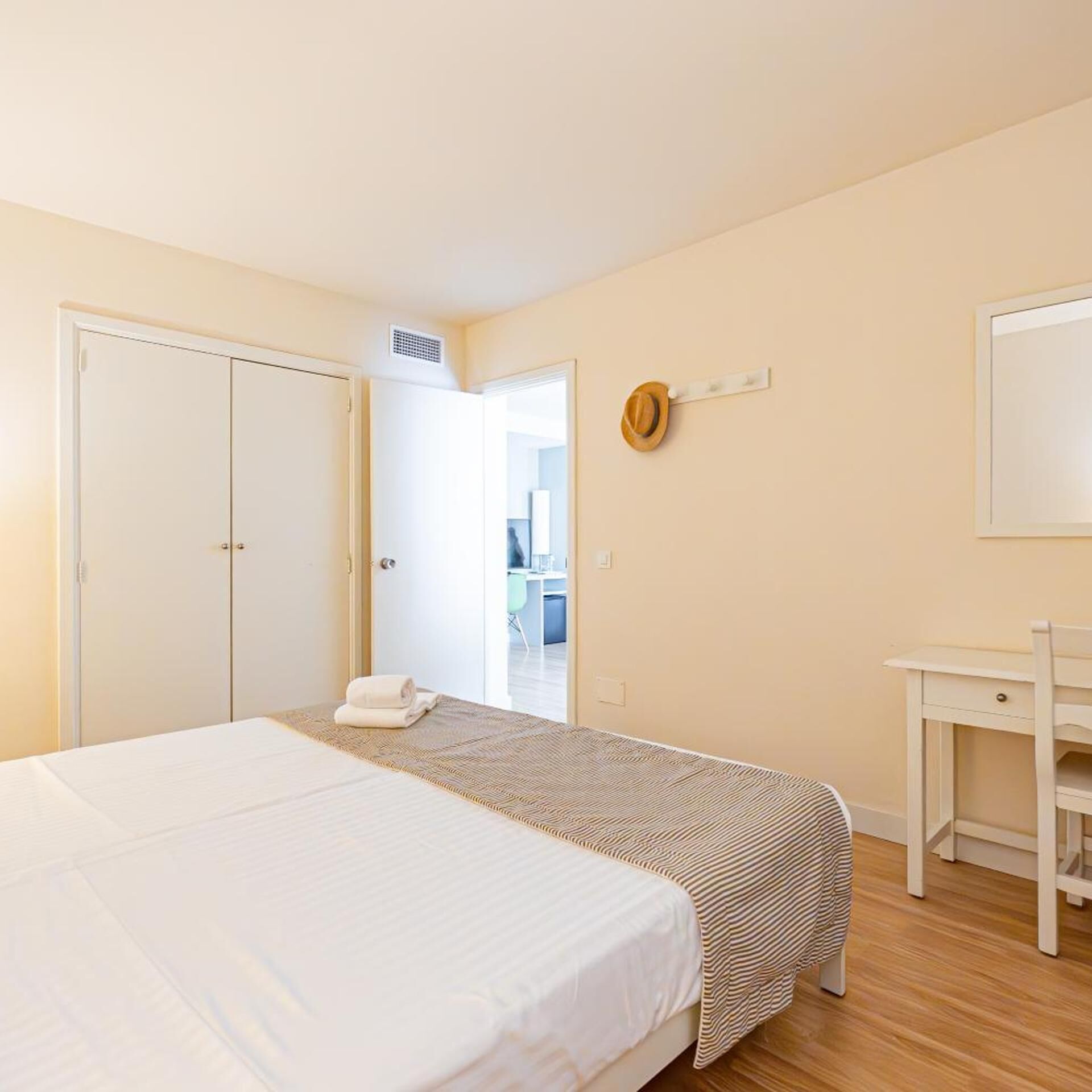 Une chambre d’hôtel avec un lit, un bureau et une armoire.