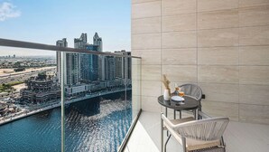 Un balcon donnant sur un paysage urbain et sur une étendue d’eau.