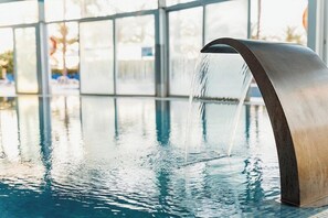 A modern indoor pool with a sleek, metallic water feature. - Senator Aguilas Hotel (Aguilas)