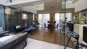 A modern hotel lobby with glass partitions, a dining area, and a bar. - Miiro Borneta (Barcelona)