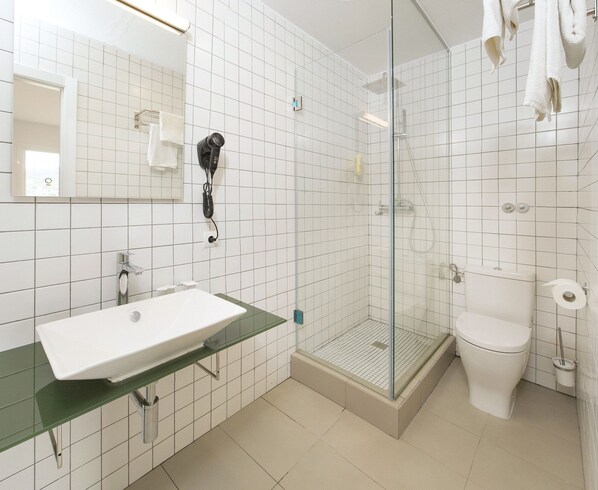 A modern bathroom with a glass shower enclosure, a white sink, and a toilet. - Vibra Riviera Apartments (Sant Josep de sa Talaia)