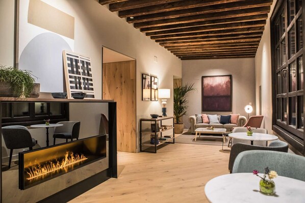 A modern living room with a fireplace, a sofa set, and a dining area.