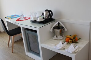 A compact kitchenette with a coffee maker, a small refrigerator, a fruit bowl, and a glass of water on the counter. - Playasol Aquapark & Spa Hotel (Roquetas de Mar)