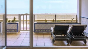A room with a view of the beach, a sliding glass door, and two lounge chairs. - Playasol Aquapark & Spa Hotel (Roquetas de Mar)