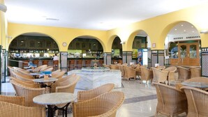 A spacious lobby with wicker furniture, a central fountain, and a bar area. - Playasol Aquapark & Spa Hotel (Roquetas de Mar)