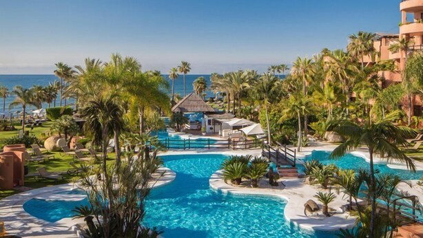 A resort with a large pool, palm trees, and a view of the ocean. - Hacienda Del Mar Melia Collection (Estepona)
