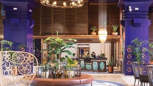 A lobby with a reception desk, seating area, and decorative plants. - Hacienda Del Mar Melia Collection (Estepona)