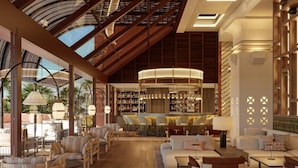 A spacious lounge area with comfortable seating, a bar with a curved light fixture, and a high ceiling with wooden beams. - Hacienda Del Mar Melia Collection (Estepona)