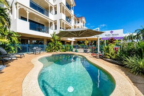 Ein Hotel mit Pool, Außenbereich und einem Schild mit der Aufschrift 'Park Regis Anchorage - Townsville'.