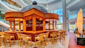 A spacious atrium with a central bar area featuring wicker chairs and a bar counter. - Sbh Costa Calma Palace (Pajara)