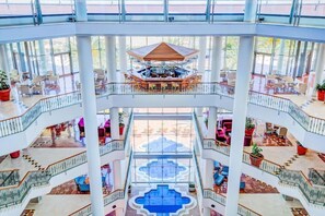 A multi-level atrium with a central pool, multiple seating areas, and a prominent bar area. - Sbh Costa Calma Palace (Pajara)