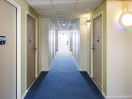 A hotel hallway with doors numbered 506 and 505, carpeted floors, and a ceiling with recessed lighting.