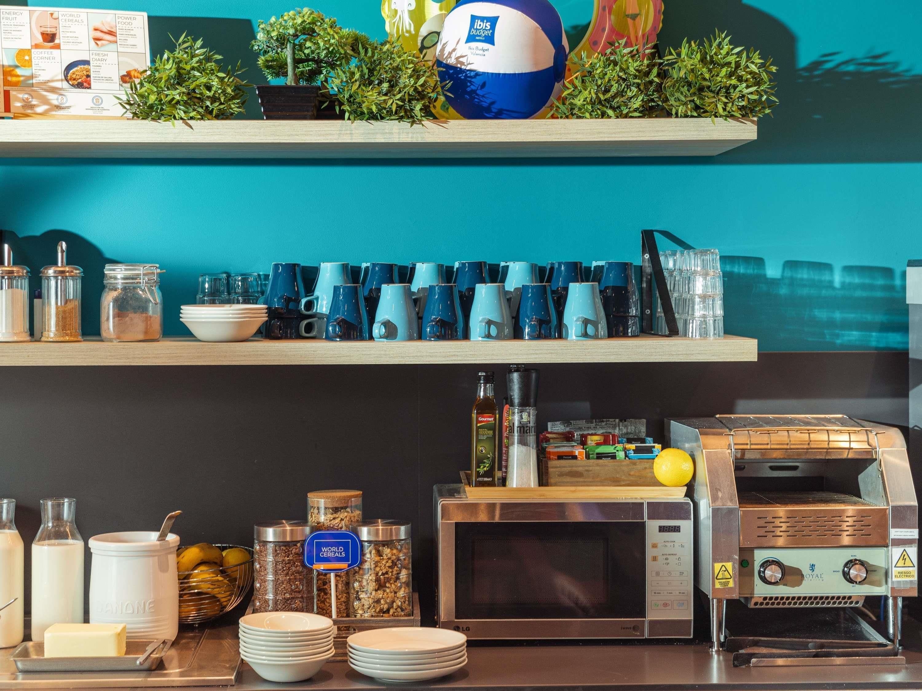 A breakfast bar with coffee mugs, a microwave, and a coffee machine.