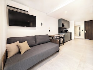 Suite Deluxe, balcón | Área de sala de estar | Smart TV de 43 pulgadas con canales digitales 
