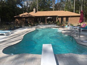 A swimming pool with a brick house in the background. - katstreehouse Forest Villa Oasis - Private Pool, Pet Friendly, Near Waterfall (Tullahoma)