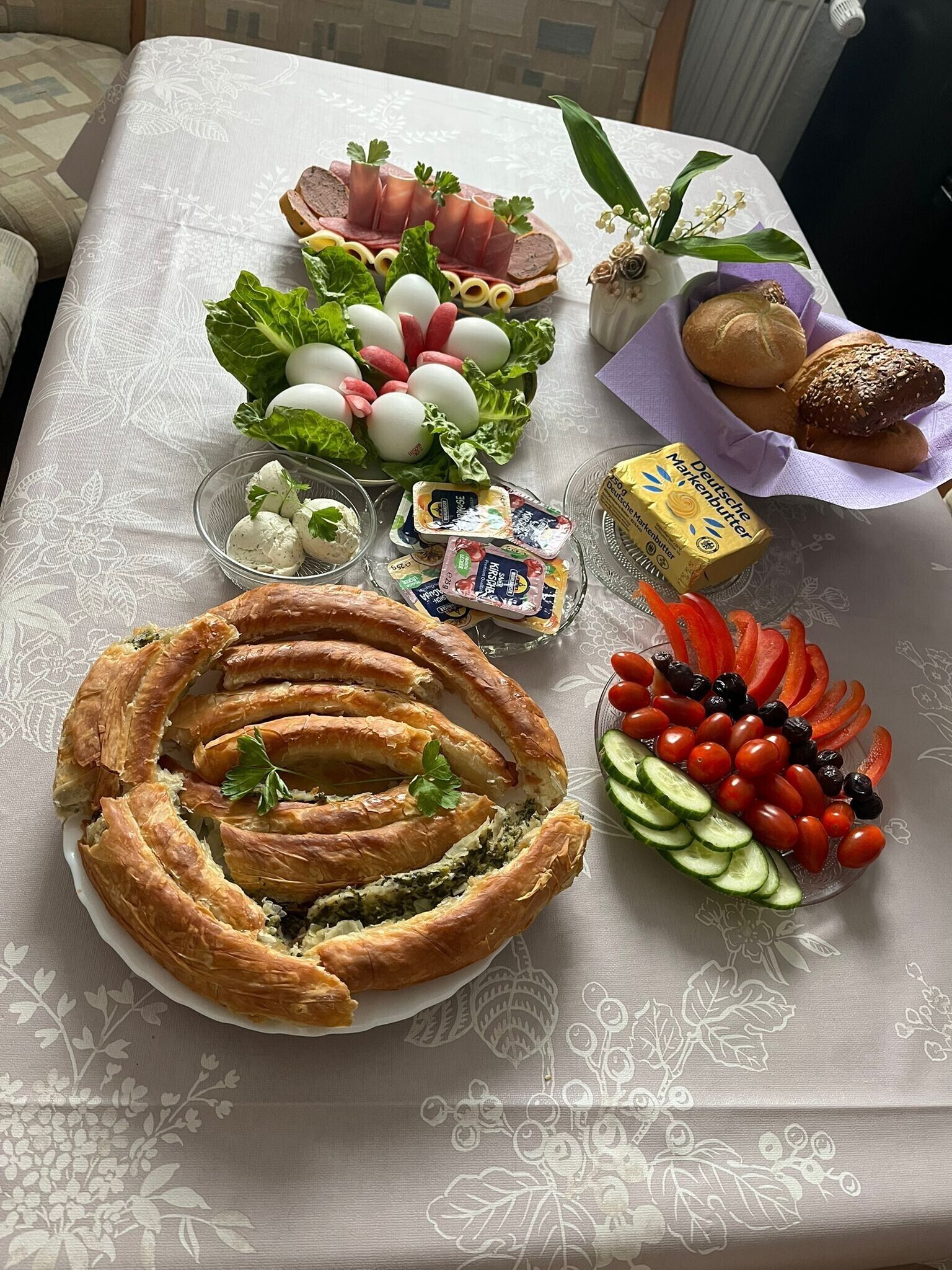 Pöydällä on erilaisia ruoka-aineita, kuten leivonnaisia, kananmunia, leipää ja salaattia.