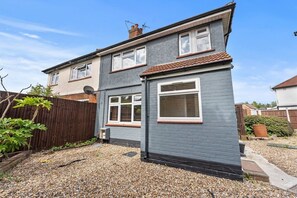 A two-story residential house with a grey exterior, a tiled roof, and a gravel driveway. - Elegant 3-Bedroom House in the Heart of Windsor (Berkshire)